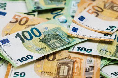 50 ve 100 banknotluk çeşitli banknotlar düz bir yüzeye yayılarak karmaşık tasarımları ve canlı renkleri vurguluyor