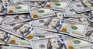 Sayısız yüz dolarlık banknotların yakın plan çekimleri ayrıntılı tasarım unsurlarını ve Benjamin Franklin 'in para birimindeki imajını vurguluyor.