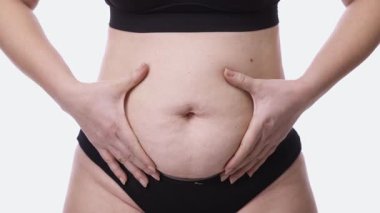 Kadının karnına yaklaşın. Elleri yavaşça karın bölgesini sarsın.