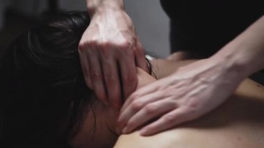 İki elin çıplak bir kadının sırtında masaj yapması.