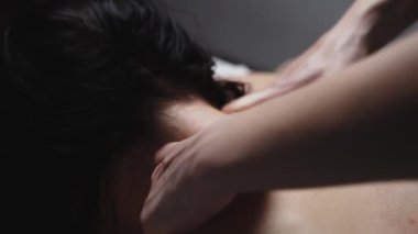 İki elin çıplak bir kadının sırtında masaj yapması.