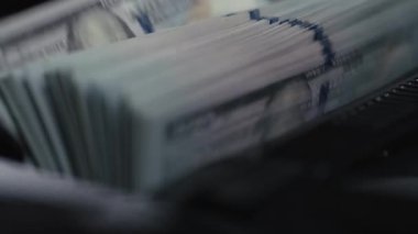 Karanlık bir yüzeye düzgünce dizilmiş yığılmış banknotların yakınlaştırılması