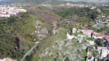 Scalea güney İtalya 'daki antik bir Norman şatosunun sinematik hava yörüngesi mavi deniz ve yemyeşil dağlarla kaplı geniş Lao Nehri vadisini gözler önüne seriyor.