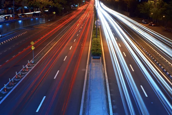 Long exposure photo of traffic with blurred traces from cars — Stock Photo, Image