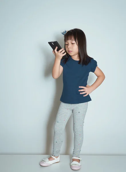 Asiatiska liten flicka med mobiltelefon — Stockfoto