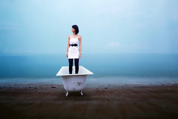 Plajda küvet içinde duran genç kadın — Stok fotoğraf
