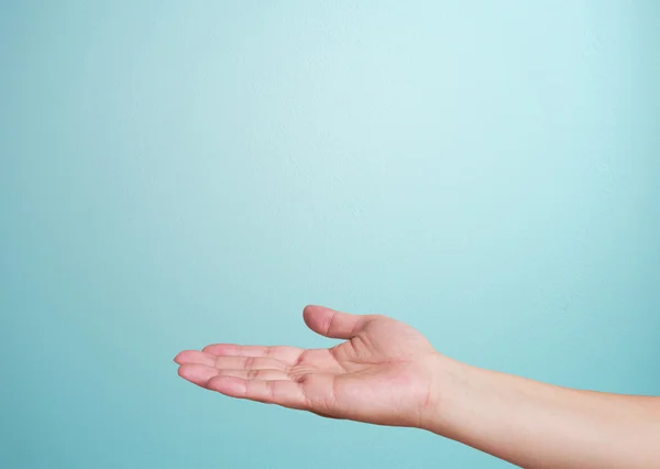 Menschliche Hand auf blauem Hintergrund — Stockfoto