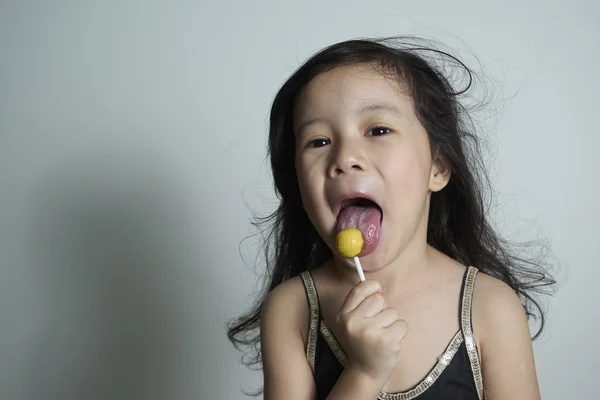 Niedliches kleines Mädchen, das Lollypop isst — Stockfoto