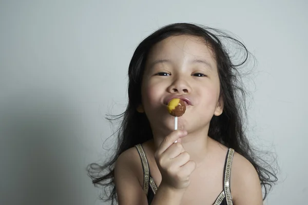 ロリポップを食べるかわいい女の子 — ストック写真