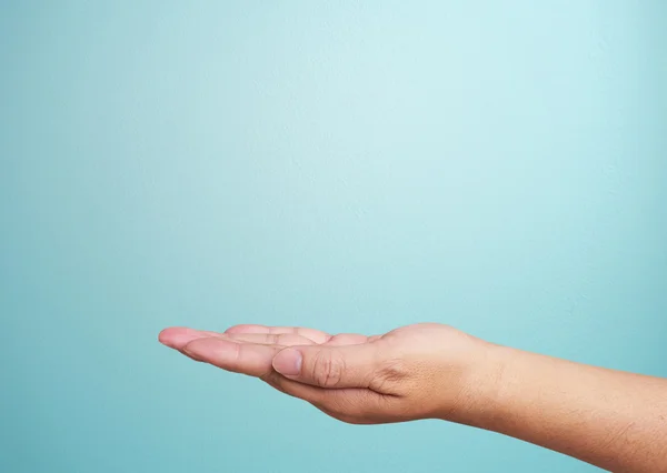 Menschliche Hand auf blauem Hintergrund — Stockfoto