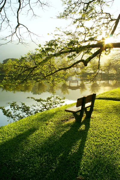 Деревянная скамейка у озера — стоковое фото