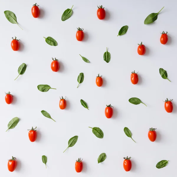 Cherry tomatoes and basil leaves pattern. — Stock Photo, Image