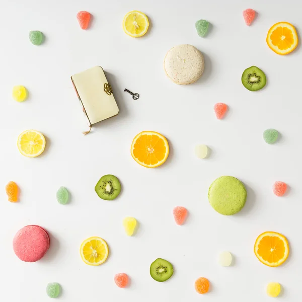 Modèle de fruits lumineux coloré avec livre et bonbons sur le dos blanc — Photo
