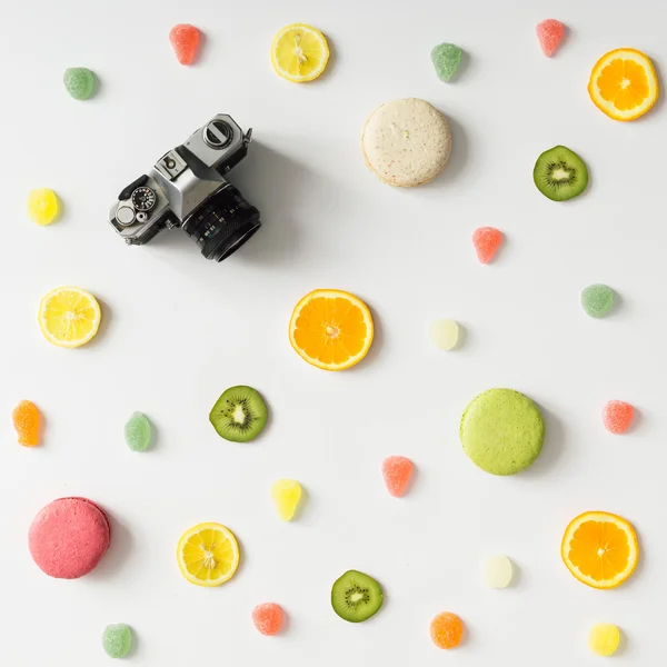 Modèle de fruits lumineux coloré avec caméra et bonbons sur ba blanc — Photo