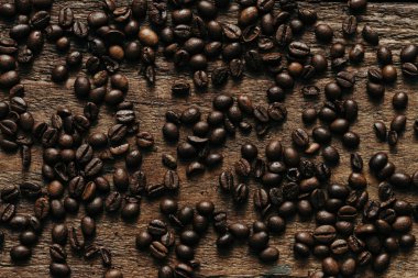 Kahve çekirdekleri ahşap arka plan üzerinde. Düz yatıyordu