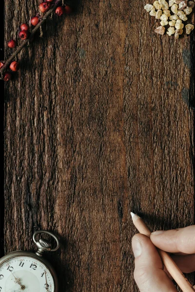 Mano masculina sosteniendo pluma blanca sobre fondo de madera —  Fotos de Stock
