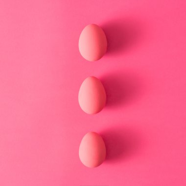 Pembe bir arka plan üzerinde üç yumurta