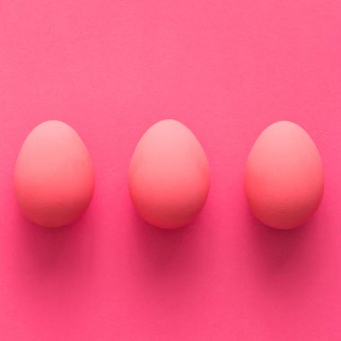 Pembe bir arka plan üzerinde üç yumurta