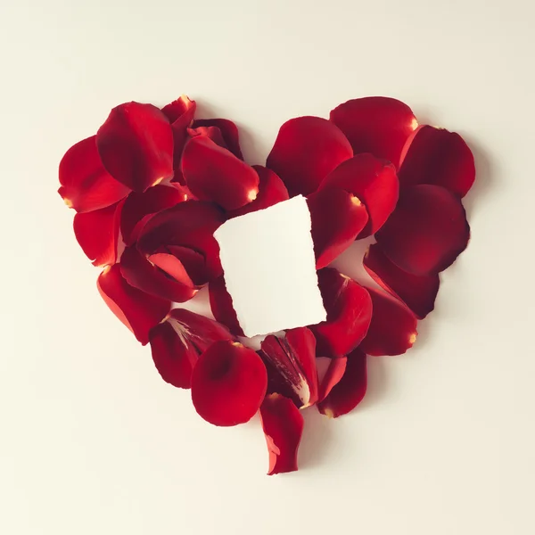 Rode rozenblaadjes in de vorm van een hart - liefde concept — Stockfoto