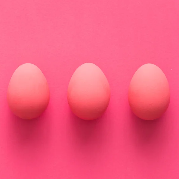 Pembe bir arka plan üzerinde üç yumurta — Stok fotoğraf