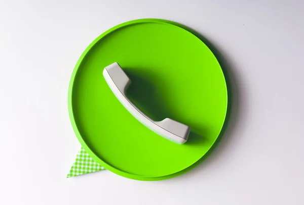 Konuşma balonu simgesinin gündelik nesneler yapılmış yeşil telefon ahizesi — Stok fotoğraf