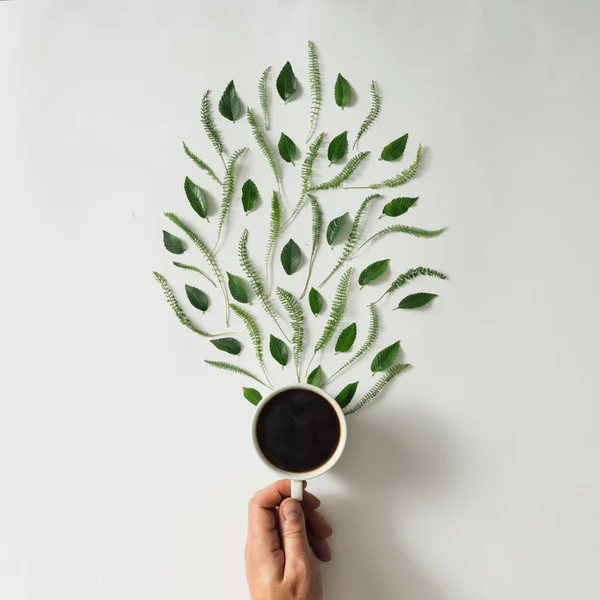 Koffiekopje met bladeren — Stockfoto