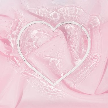 Suyun içindeki kalp şeklini ipek kumaşla süsledim. Sevgililer Günü ve kadınlar için arka plan tasarımı. Minimum düzlük.