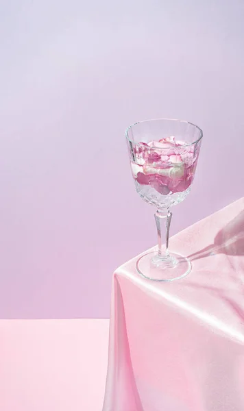 Copo Champanhe Cheio Pétalas Flores Mesa Com Tecido Seda Rosa — Fotografia de Stock