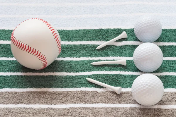 Pelotas sobre un fondo rayado golf y béisbol y clavos — Foto de Stock