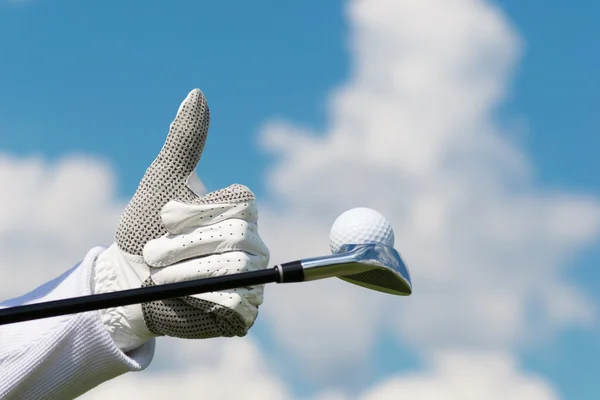 Contro il cielo blu mano mostra classe e pallina da golf — Foto Stock