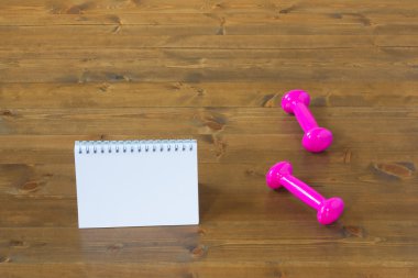 pembe dumbell ve spor salonunda yerde dizüstü