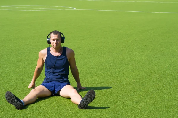 En el campo de fútbol, un hombre sentado — Foto de Stock