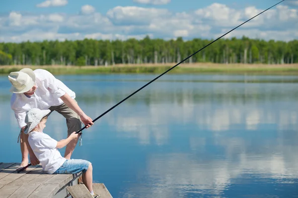 Μπαμπάς και γιος που αλιεύονται τα ψάρια και τραβήξτε το — Φωτογραφία Αρχείου