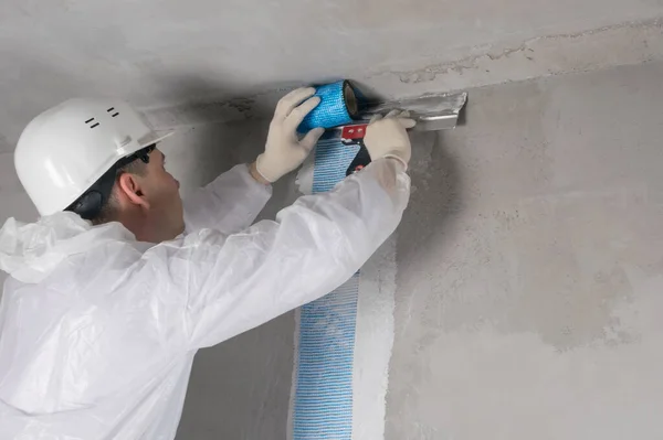 Trabajador Casco Traje Pega Una Malla Especial Una Grieta Pared — Foto de Stock