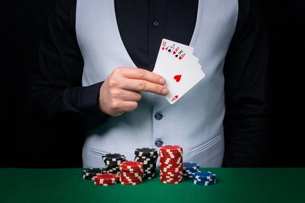 ポーカーゲームでカードの組み合わせを保持ディーラーの前の緑のテーブルの上に大きな賭け ストックフォト