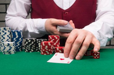 Krupiyenin elindeki ACE 'yi arka plandaki bahis çiplerine yakın plan çekeceğiz.