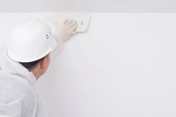 The wall repairman finishes the wallpapering, on the right is the place for the inscription — Stock Image Wall Repairman Finishes Wallpapering Right Place Inscription Royalty Free Stock Images