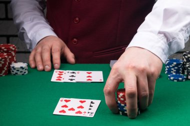 Satıcı kazandıklarını yeşil poker masasında dağıtır.