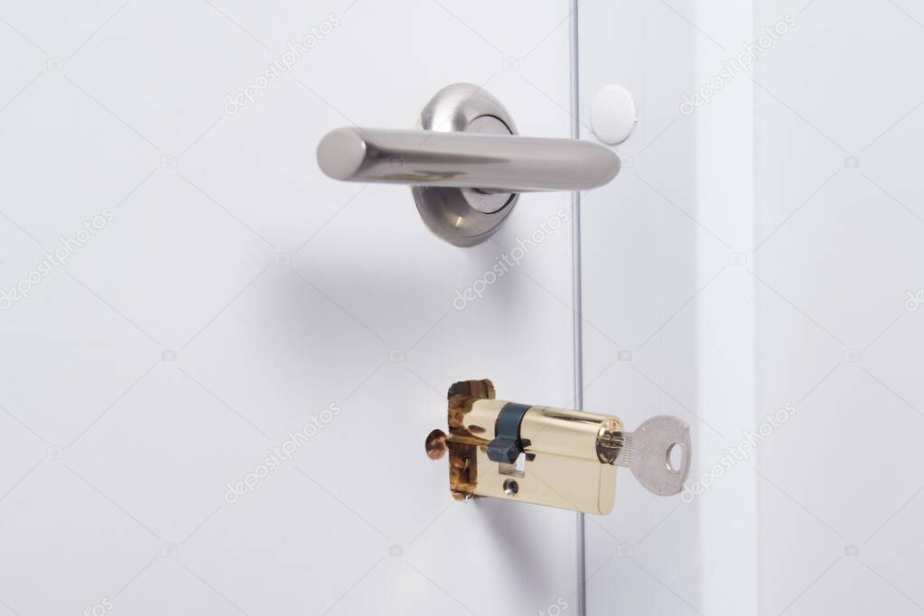 a key-locking mechanism is inserted into the white door, close-up