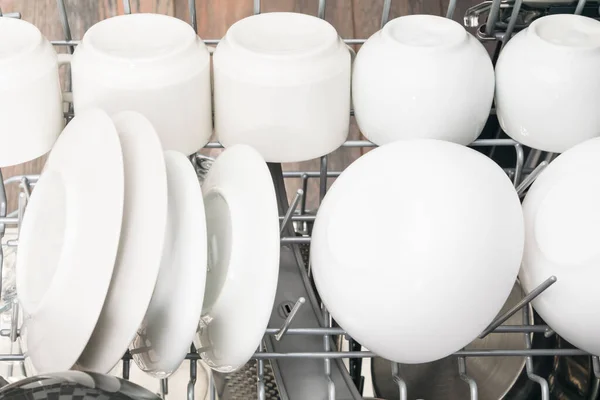 洗碗机间的白色咖啡杯和茶托 — 图库照片