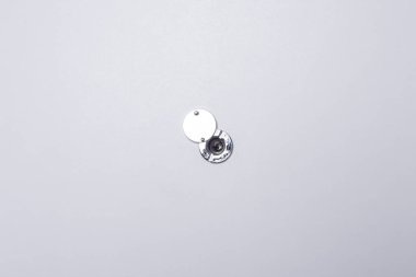 Kapının beyaz arka planında, eve gelenleri gözetlemek için bir gözetleme deliği var.