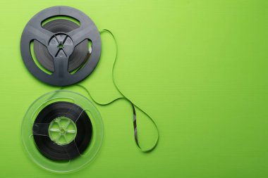 Yeşil arka planda, müzik dinlemek için iki retro manyetik bobin, sağda yazıtlar için bir yer var.