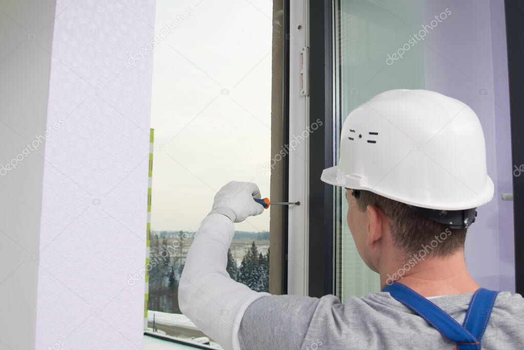 the window installer adjusts the windows of the apartment