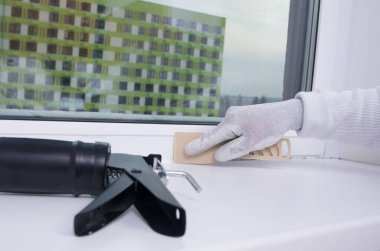 silicone distribution, for sealing the cracks of windows and window sills, with a plastic spatula clipart