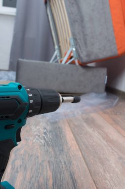 Mobilya montajı için bir tornavidayı açık bir kanepenin arka planına yakın çekim