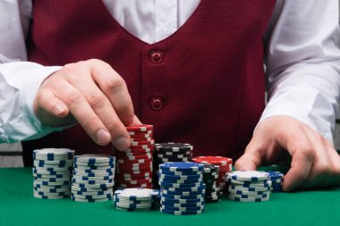 Kumarhanede para için, büyük bahisler için, kırmızı yeleğin arka planında oynamak için çok sayıda renkli fiş.