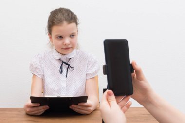 Mola sırasında, blogcu kız, masada, görüntülü bir sohbet için hazırlanıyor, asistan senaryoyu gösteriyor ve telefonu açıyor, kapatıyor.