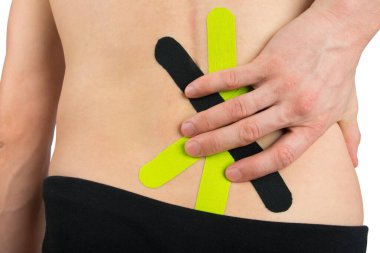 Sırtın arkasında, spor yaparken sırt ağrısının azalmasını kolaylaştırmak için bir kinesio bandı yapıştırılır.