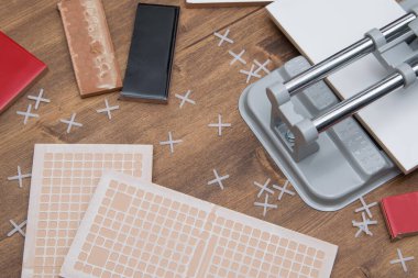 Plastik haçlar ve döşeme aletleri ahşap yüzeye saçılmış.