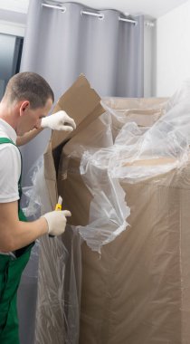 Gülümseyen kurye, kargoyu bir bıçakla açar.